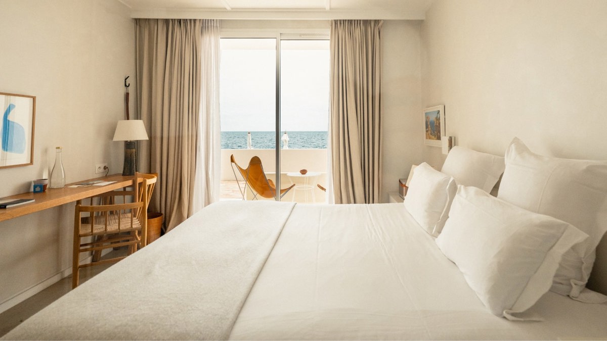 A bedroom’s balcony glass door offers a wonderful and breathtaking view of the ocean.
