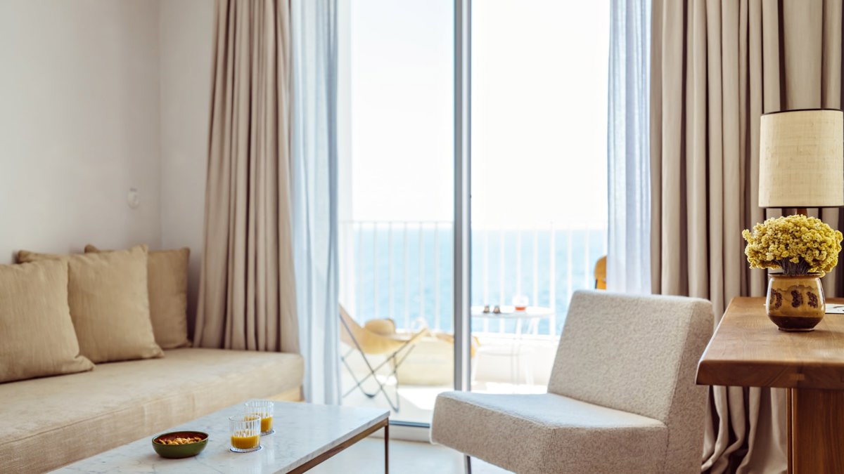 A sofa set is placed near the balcony door, offering a wonderful ocean view.