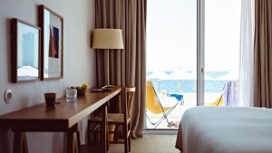 Two portraits are mounted above the table positioned directly in front of the cozy bed.