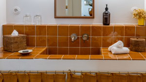Une photo prise montre un plan de travail de lavabo de couleur orange avec une finition soignée et vibrante.