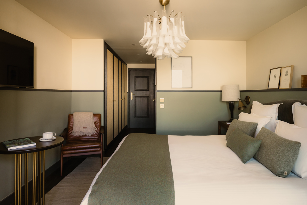 Chambre du Fitz Roy avec fauteuil en cuir, espace dressing et lustre en verre de Murano