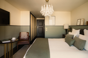 Chambre du Fitz Roy avec fauteuil en cuir, espace dressing et lustre en verre de Murano