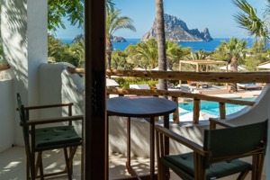 Une table avec deux chaises se trouve sur le balcon du complexe, offrant une vue imprenable sur les montagnes de l'île.