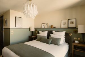 Chambre du Fitz Roy avec photographies de ski vintage, murs vert sauge et lustre en Murano