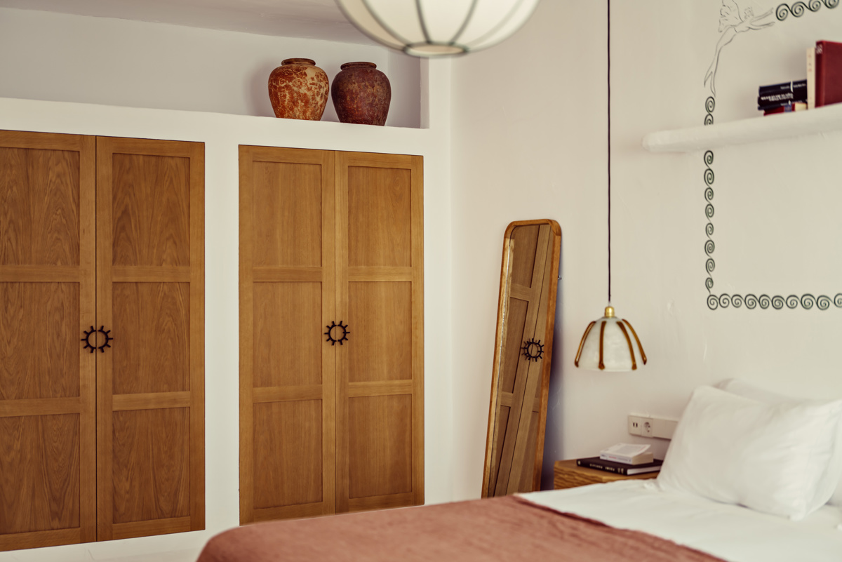 Un long miroir est placé dans le coin de la chambre, avec deux vases au-dessus des étagères.