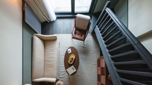 Une photo prise à l'étage montre un espace de vie avec un canapé confortable et une table ovale.