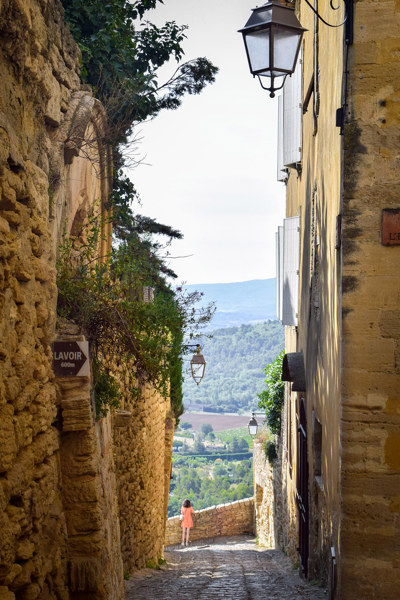 Ruelle pavée et vue sur la vallée dans le village perché de Gordes, Luberon