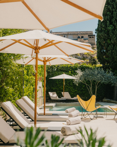 Transats et parasols au bord de la piscine de l'hôtel Beaumier Le Moulin à Lourmarin, Luberon