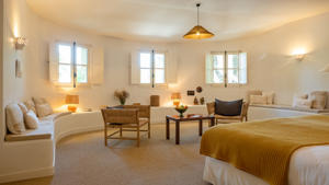 Une chambre bien agencée comprend un lit confortable, un canapé avec une table et une lampe suspendue.