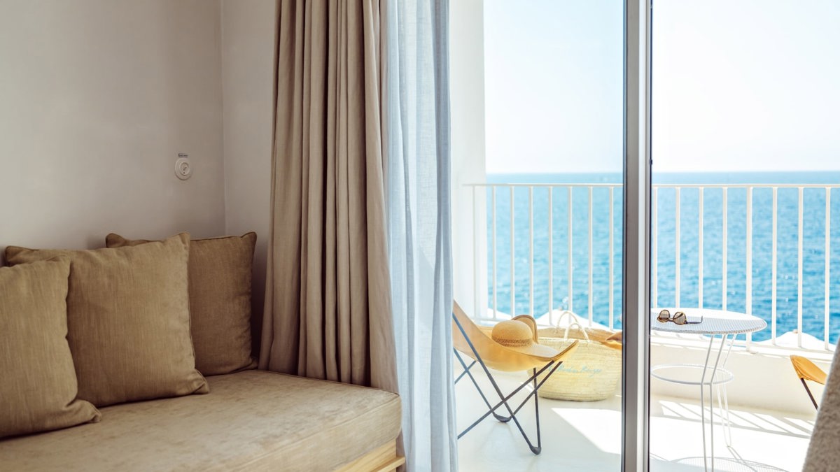 A cozy sofa set is placed near the balcony door, offering a stunning ocean view.