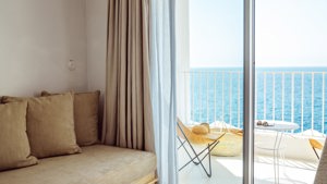 A cozy sofa set is placed near the balcony door, offering a stunning ocean view.