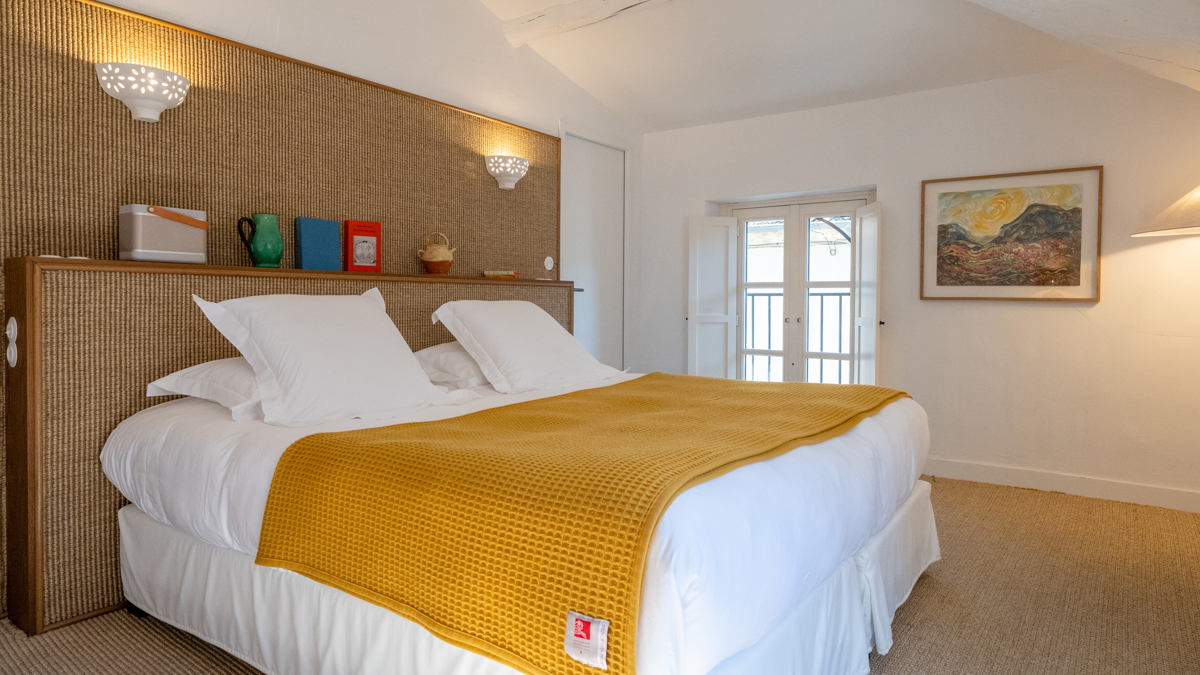 Intérieur d'une chambre supérieure à l'hôtel Le Moulin avec un lit king size.