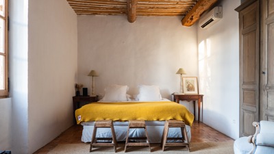 Une chambre bien organisée comprend un lit confortable, deux tables de chevet et trois petits sièges.