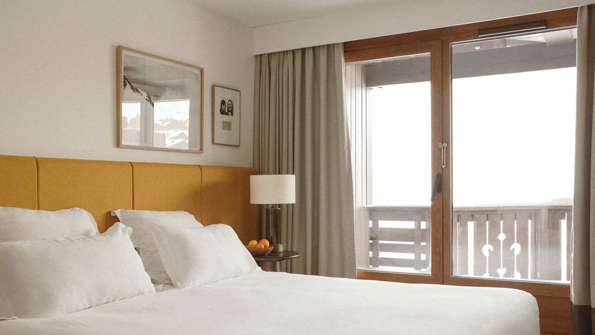 Two portraits are mounted above the bed’s headboard, with a lamp on the bedside table.