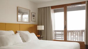 Two portraits are mounted above the bed’s headboard, with a lamp on the bedside table.