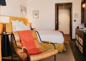 Cama doble y mobiliario en habitación Confort Val Thorens.