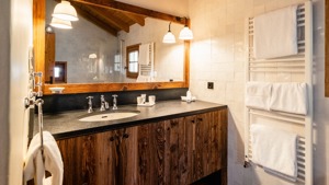 A clicked photo of a bathroom shows properly organized bathing essentials near the washbasin countertop.