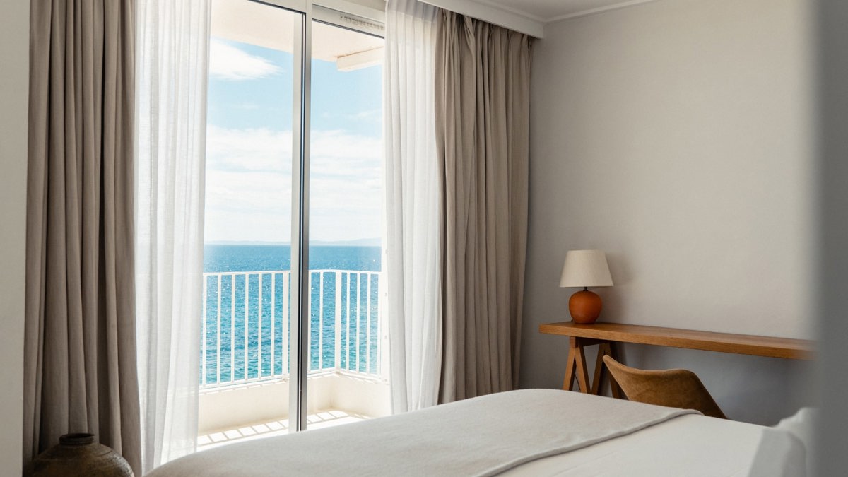 A wonderful view of the ocean is visible through the balcony glass door.