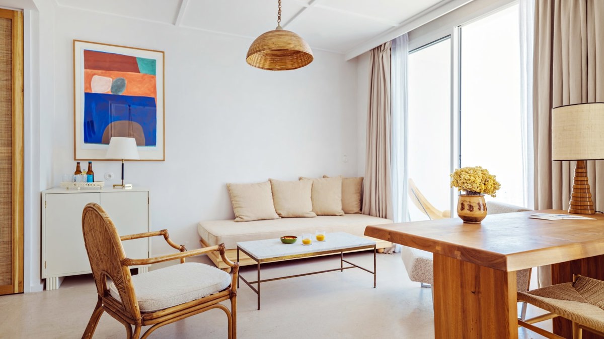 A set of cozy chairs is placed near the balcony door, with a portrait mounted above the table beside the sofa.