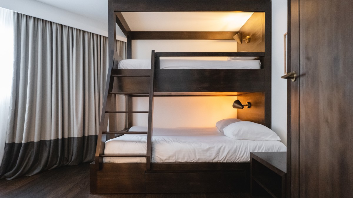 A photo captures a double-decker bed with stairs conveniently fitted into its frame.