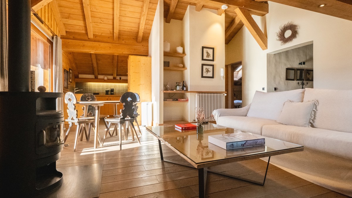 Cozy hotel room with wood-paneled walls, a large bed with white linens, and warm lighting.