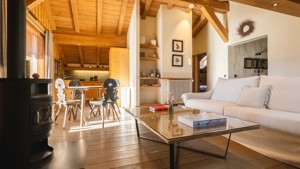 Cozy hotel room with wood-paneled walls, a large bed with white linens, and warm lighting.