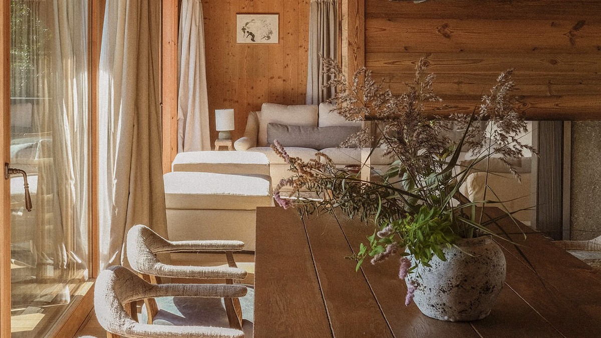 A photo of the living space features a cozy sofa by a window and a flowerpot.