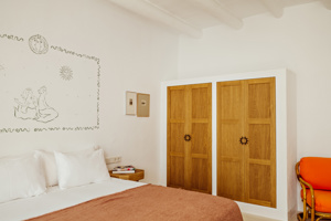 Une chambre bien organisée comprend un lit confortable, une table de chevet avec une lampe et des portraits au-dessus.