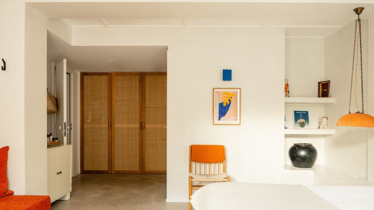 A small decorative vase is placed on the side table, with a portrait mounted above the bed.