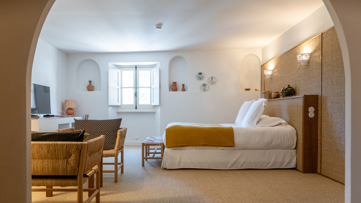 Une chambre bien organisée comprend un lit confortable, un ensemble de chaises et une télévision en face.