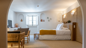 Une chambre bien organisée comprend un lit confortable, un ensemble de chaises et une télévision en face.