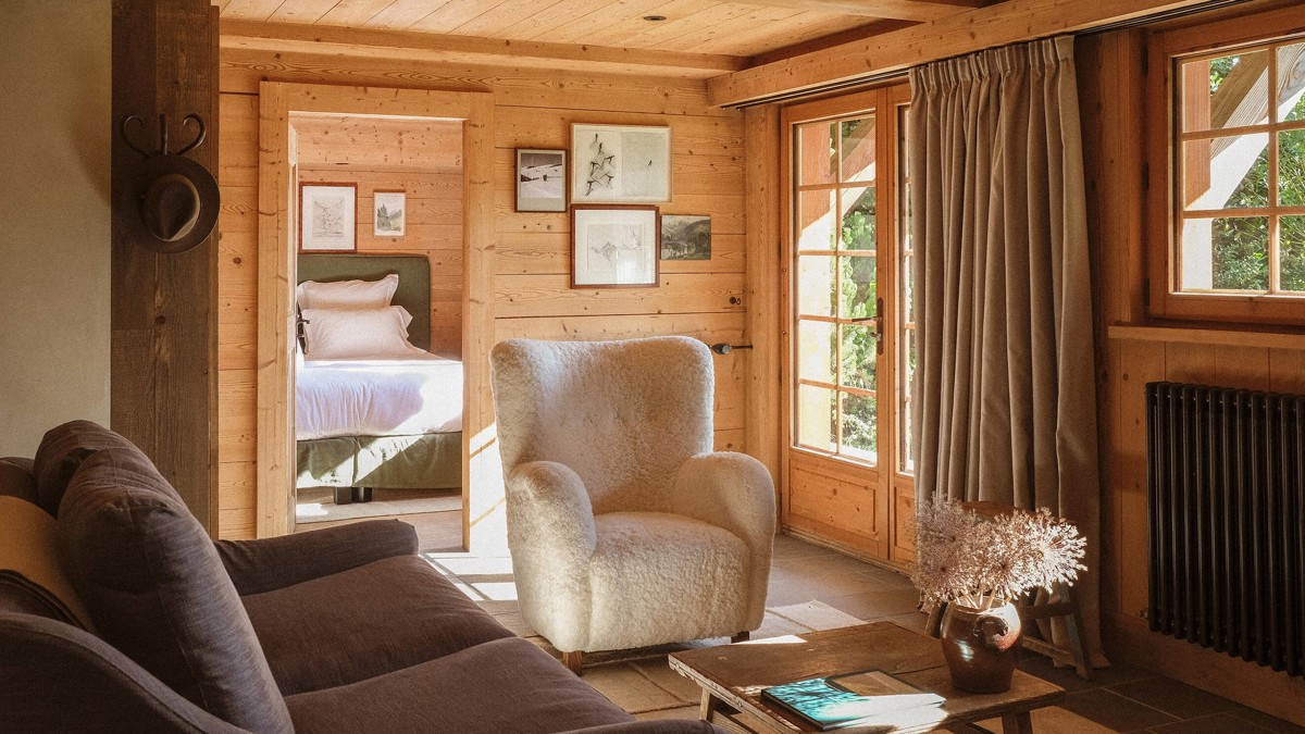 A living space features a cozy sofa set near the glass door, with portraits above.
