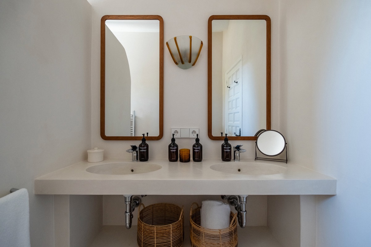 Deux miroirs verticaux sont montés au-dessus du lavabo dans la salle de bain.