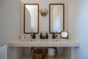 Deux miroirs verticaux sont montés au-dessus du lavabo dans la salle de bain.