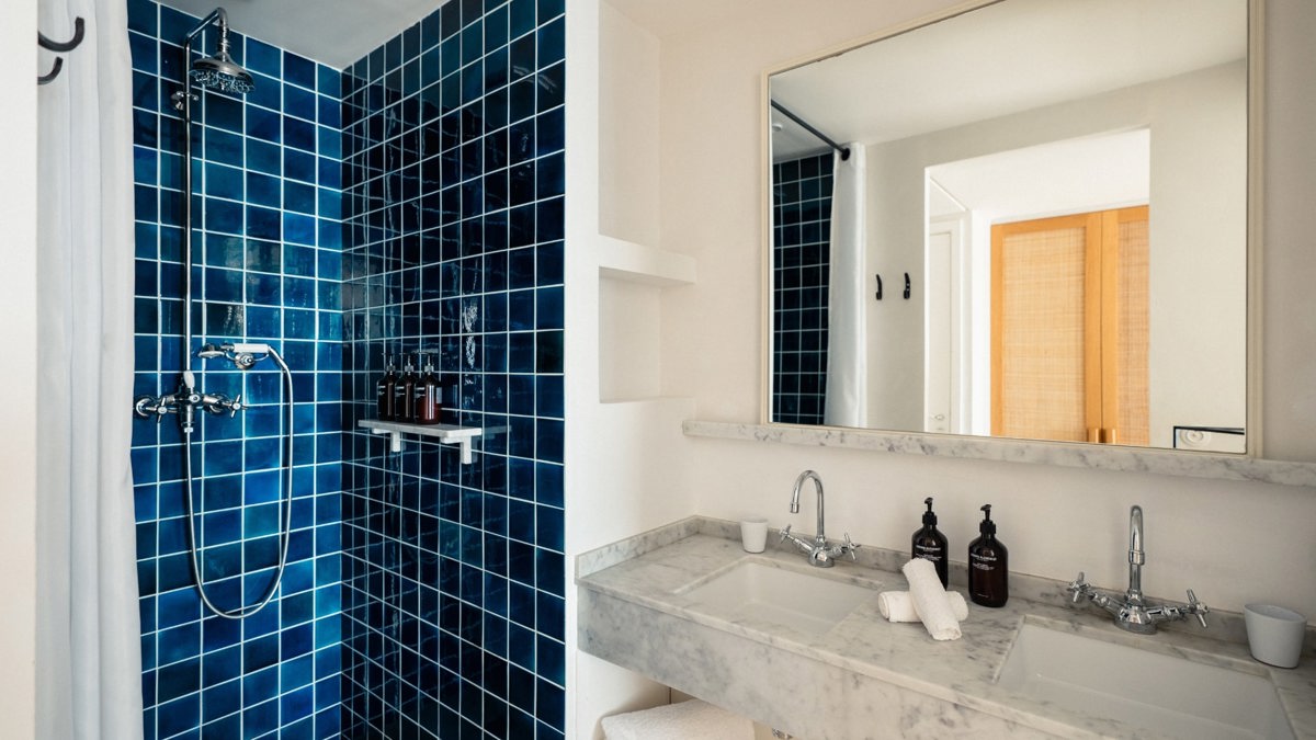 A photo captures a blue-tiled bathroom, with each essential item neatly and properly arranged.