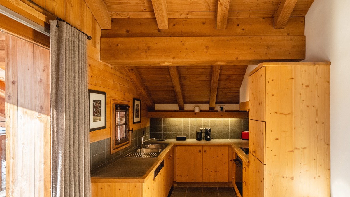 A well-organized, neat, and clean kitchen photo shows two portraits mounted on the left wall.