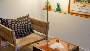 Une chaise confortable est placée dans le coin, accompagnée d'une lampe sur pied et d'une table basse.