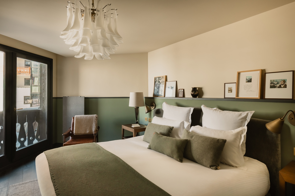 Chambre du Fitz Roy avec fauteuil en cuir, balcon et vue sur le village de Val Thorens