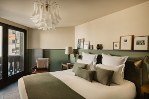 Chambre du Fitz Roy avec fauteuil en cuir, balcon et vue sur le village de Val Thorens