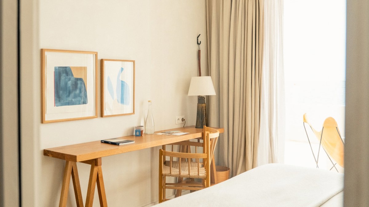 A chair is placed near the table, with two portraits mounted just above it.