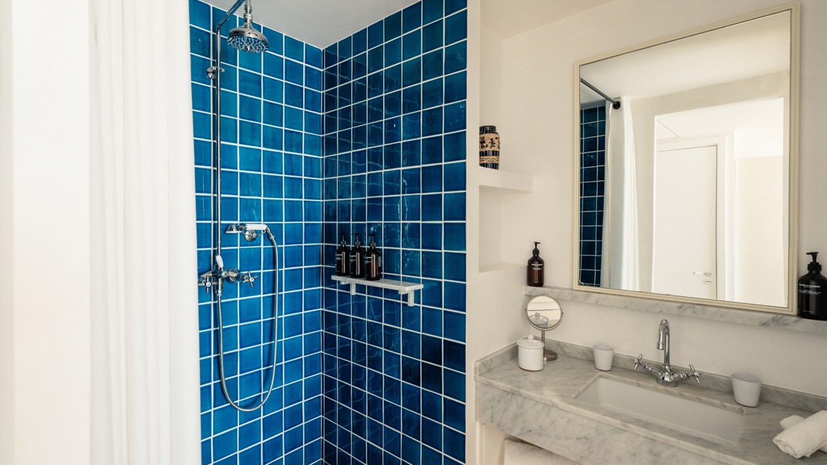 A photo captures a blue-tiled bathroom with each essential item neatly and properly placed.