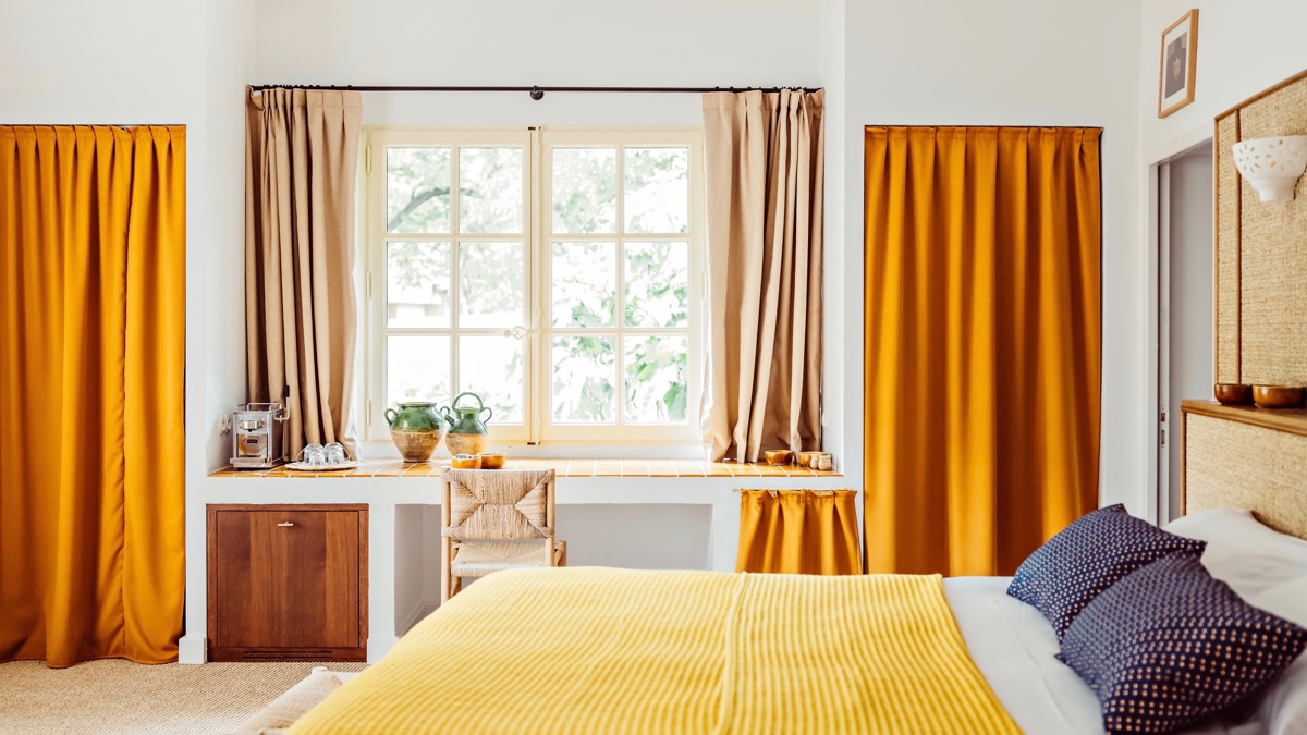 Une chambre bien organisée comprend un lit confortable et une chaise près de la table près de la fenêtre.