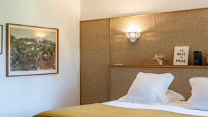 Un portrait est accroché au mur de gauche, juste à côté du lit douillet.