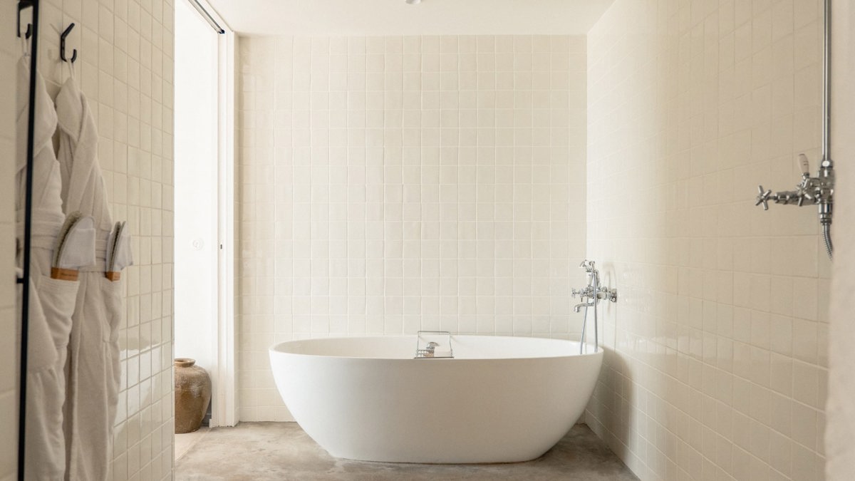 A bathtub is placed neatly in the corner of the bathroom, enhancing the space.