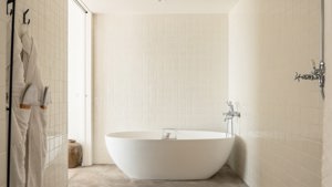 A bathtub is placed neatly in the corner of the bathroom, enhancing the space.