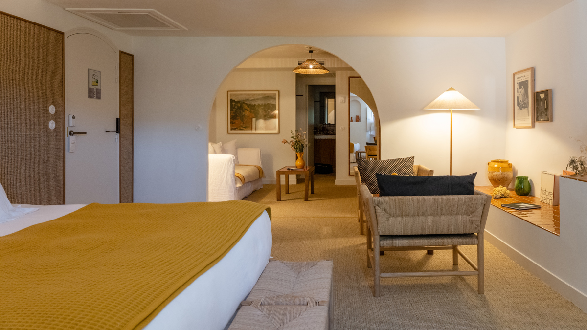 Une chambre bien organisée comprend un lit confortable, avec un ensemble de chaises et une table devant.