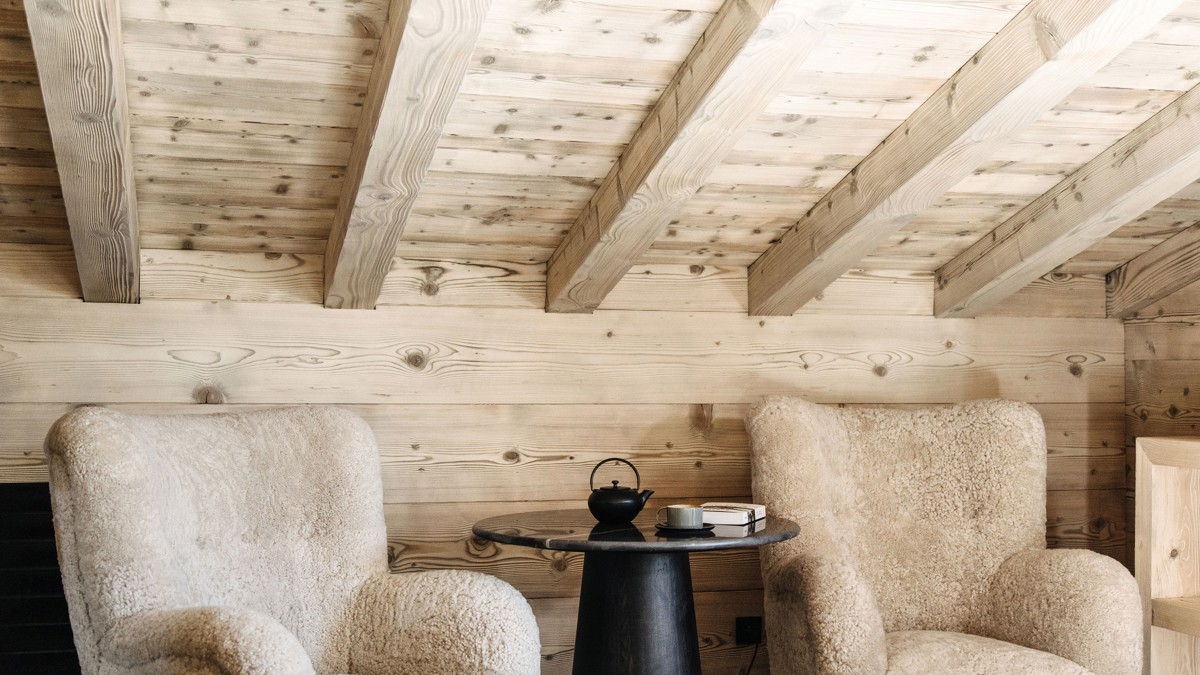 Two feather-touch sofa sets accompany a black coffee table holding a kettle, cup plate, and notebook.