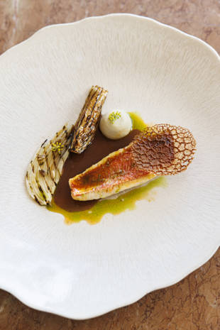 A delicately plated course of Christophe Bacquié's red mullet served with fennel and a crisp tuile, featured at the six-hands dinner in Bonnieux, Provence.