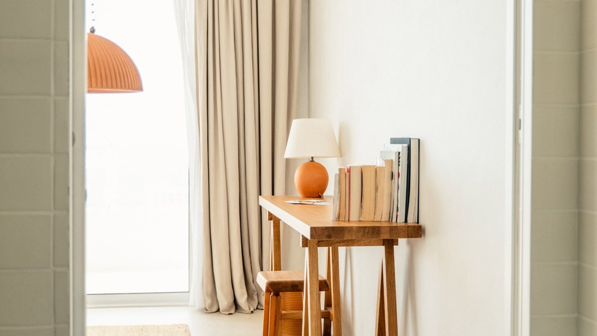 Some notebooks are placed on the table along with a small, decorative lamp.