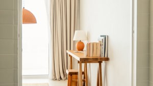 Some notebooks are placed on the table along with a small, decorative lamp.